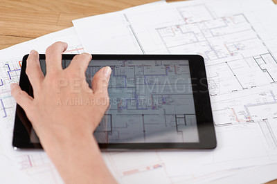 Buy stock photo Cropped image of an architect working on building plans on her digital tablet