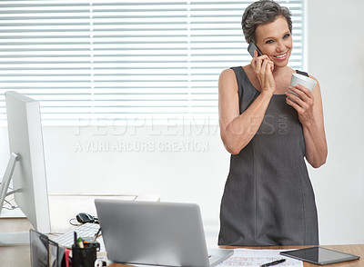 Buy stock photo A mature businesswoman talking on her cellphone while having coffee at the office