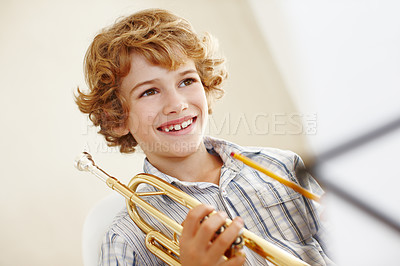 Buy stock photo Shot of a cute little boy playing the trumpet