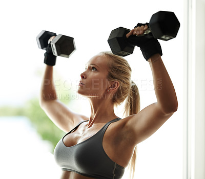 Buy stock photo Cropped shot of a beautiful young woman in workout gear lifting dumbbells