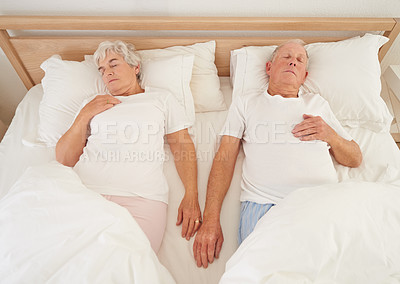 Buy stock photo Sleeping, love and senior couple in bed, resting and relaxing together on weekend in bedroom. Elderly people, retirement and dreaming at home, top view and support in marriage or relationship and nap