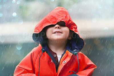 Buy stock photo Happy boy, red raincoat and little child playing or having fun with the raindrops and outdoors. Smile, kid and looking up at the sky or enjoying rainfall and showers on bokeh background 