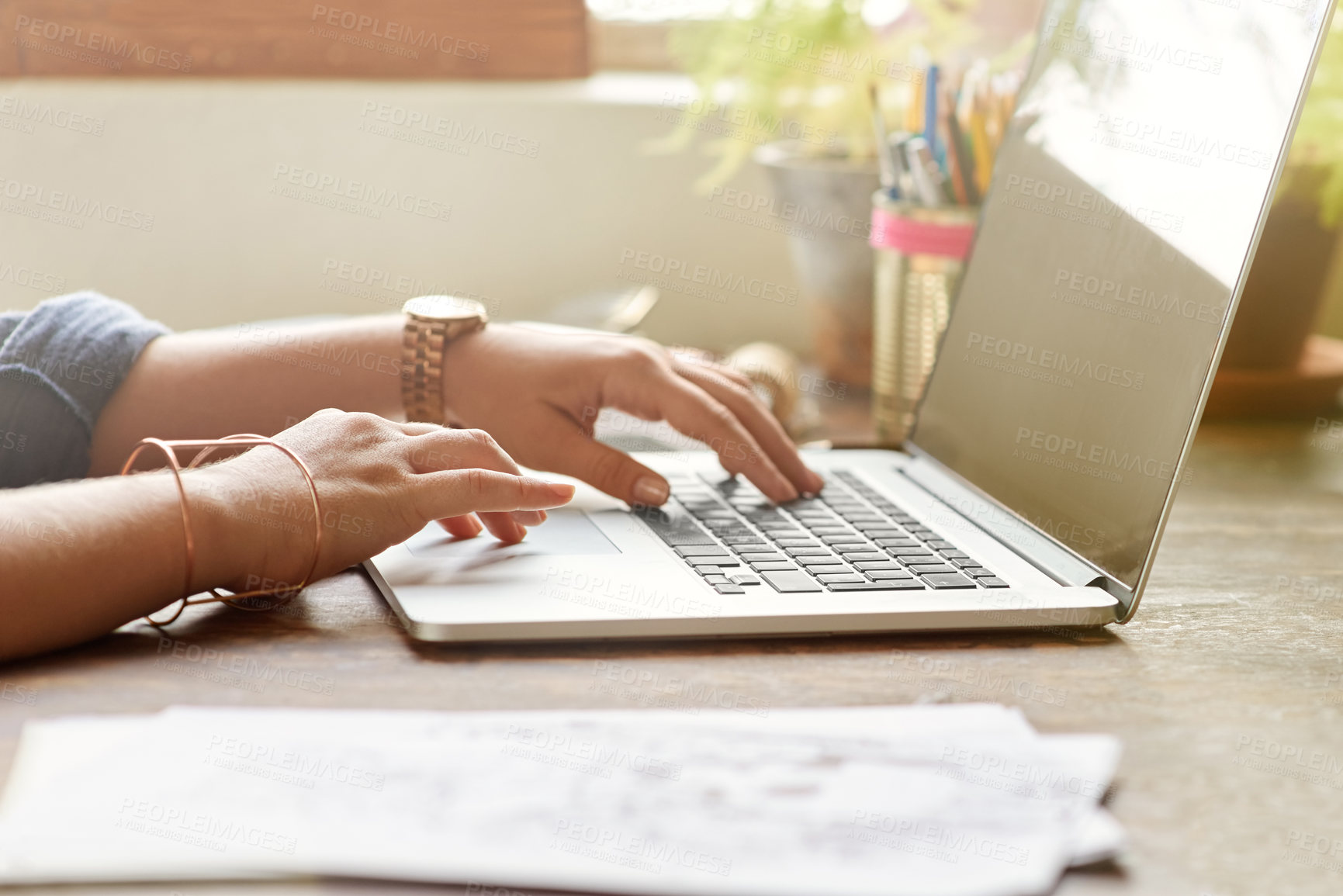 Buy stock photo Cropped shot of a young graphic designer working on her laptop at home