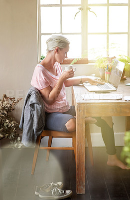 Buy stock photo Shot of a female designer working on her laptop at home