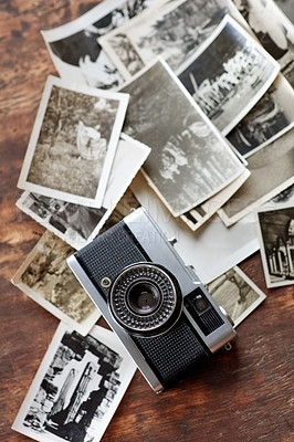 Buy stock photo Wooden desk, vintage and camera with retro photographs on black and white. Digital, old school and table with images for creativity, project and collection for filming, photoshoot and artistic