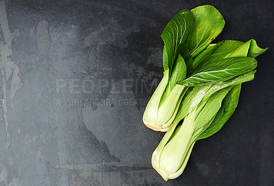 Buy stock photo Top view of leaves of chinese cabbage lying on a dark countertop