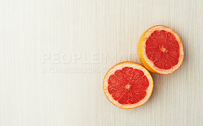 Buy stock photo Grapefruit, organic and fresh sliced in studio for nutrition, vegan diet or healthy eating. Citrus food, natural and delicious on counter top for vitamin c, wellness cuisine or weight loss snacking