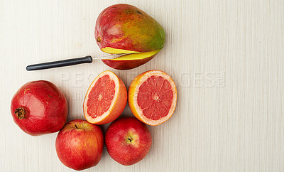 Buy stock photo Fruit, nutrition and health on table top with knife for food, diet and wellness on studio background. Mango, vegan and vitamin c for cooking, eating and flat lay of grapefruit for mock up space.