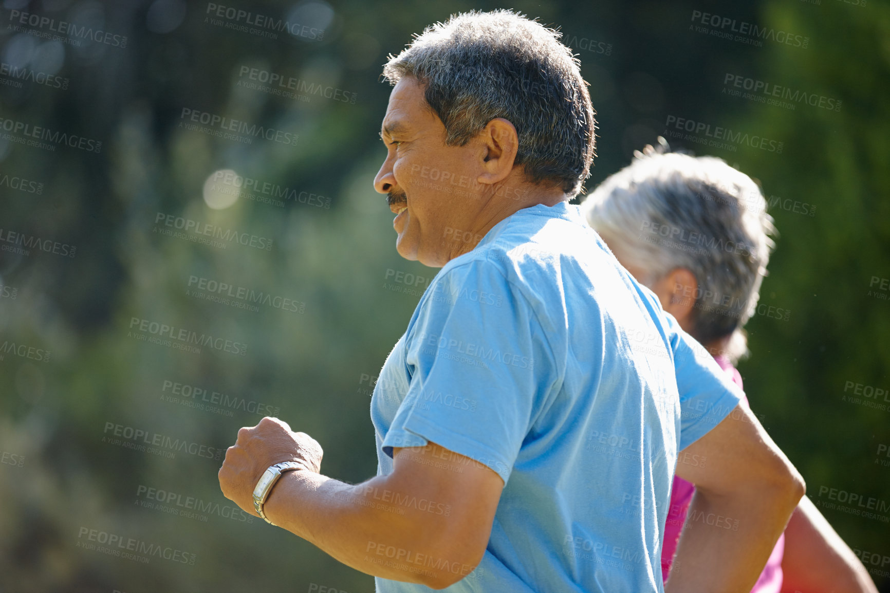 Buy stock photo Shot of a mature couple jogging together on a sunny day