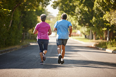 Buy stock photo Rearview shot of a mature couple jogging together on a sunny day