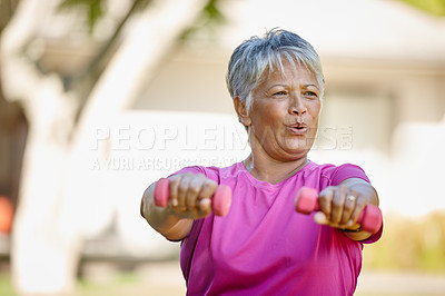 Buy stock photo Cropped shot of a mature woman lifting dumbbells outside