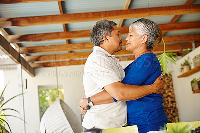 Buy stock photo Shot of a happy senior couple wrapped in a warm embrace at home