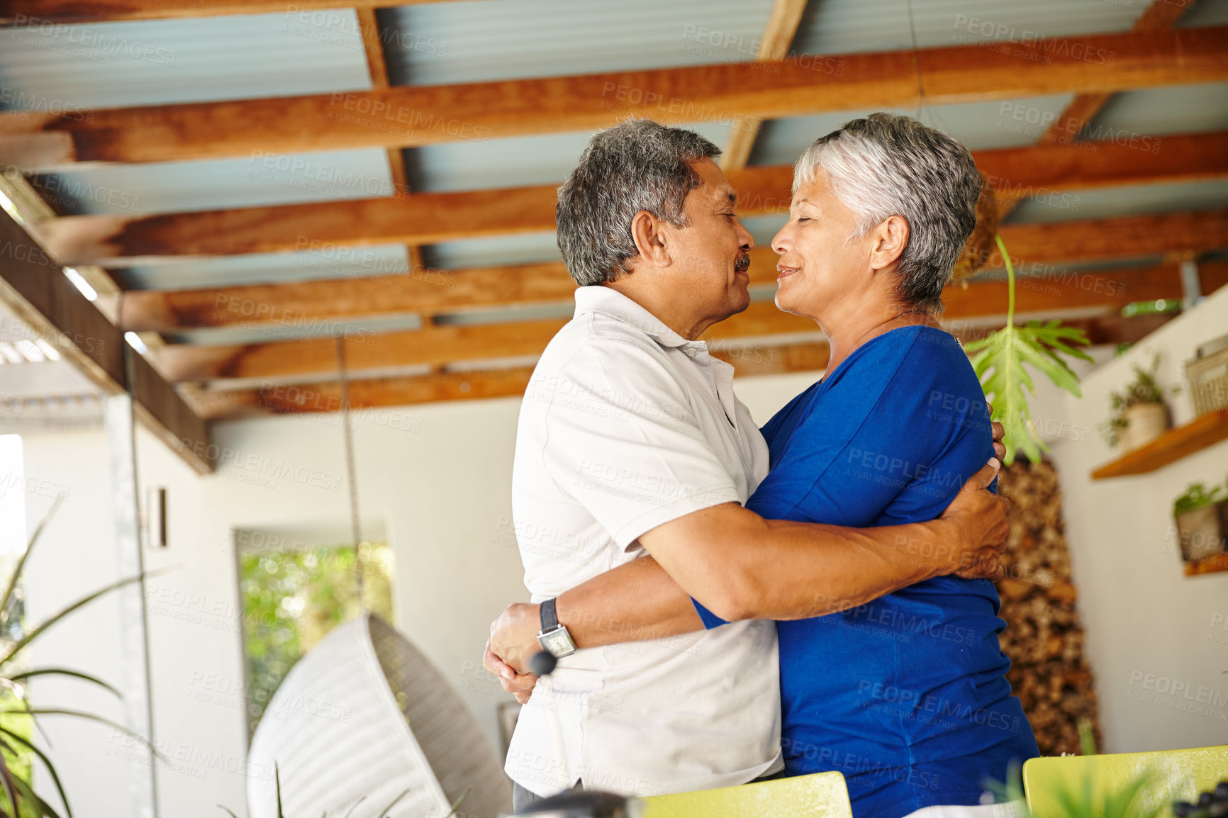 Buy stock photo Shot of a happy senior couple wrapped in a warm embrace at home