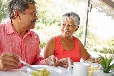 Buy stock photo Shot of a happy senior couple enjoying a leisurely breakfast together at home