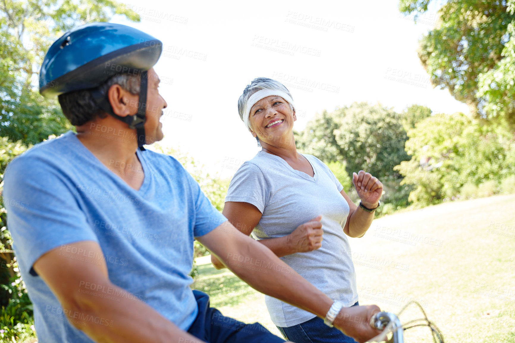 Buy stock photo Shot of a happy senior couple going for a bike ride and a jog together outdoors