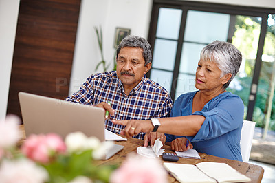 Buy stock photo Shot of a senior couple working on their budget together at home