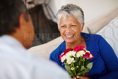 Buy stock photo Shot of a happy senior woman receiving a bunch of flowers from her husband