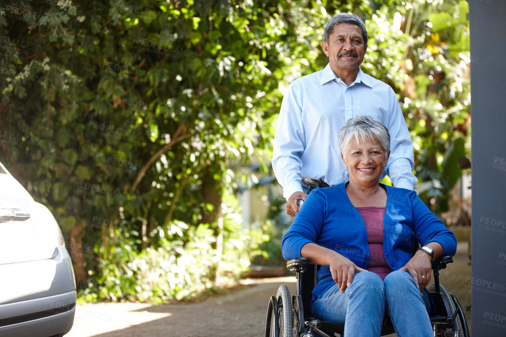 Buy stock photo Portrait of a senior man pushing his wife in a wheelchair outdoors