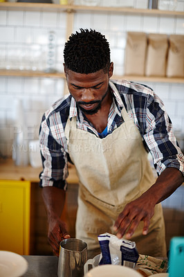Buy stock photo Cropped shot of a male barista making a cup of coffee in a cafe