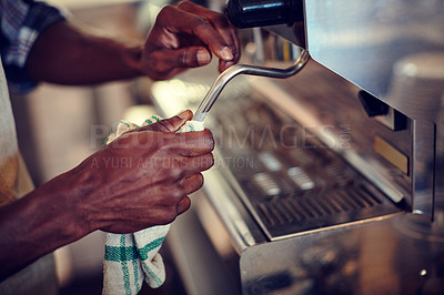 Buy stock photo Closeup shot of a barista cleaning an espresso machine at a cafe