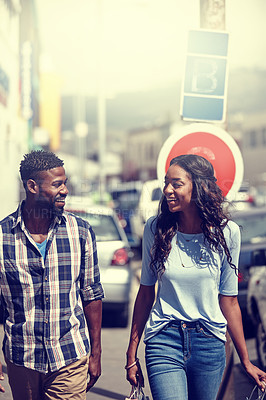 Buy stock photo Shot of a happy couple walking through an urban area