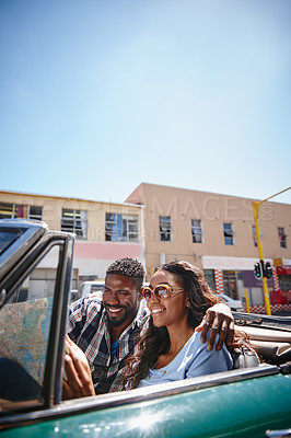 Buy stock photo Shot of a young couple reading a map while sitting in the car