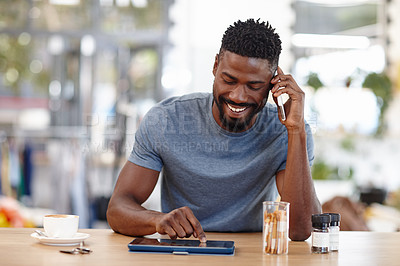 Buy stock photo Cropped shot of a handsome man sitting in a coffee shop using a cellphone and tablet