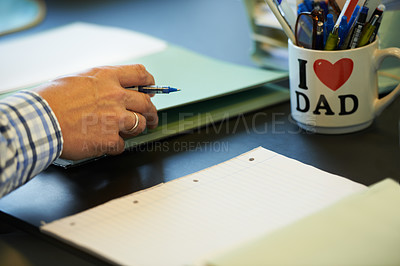 Buy stock photo Cropped image of a businessman sitting at his office desk with paperwork and stationary in front of him