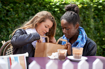 Buy stock photo Women, coffee shop and bag with bakery treat outdoor sitting at a table with hot drink. Young female person, curious and present with diversity and paper bags at a cafe and restaurant sitting