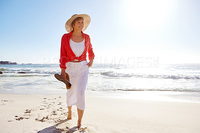 Buy stock photo Shot of an attractive mature woman enjoying a day at the beach