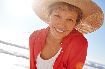Buy stock photo Portrait of an attractive mature woman enjoying a day at the beach