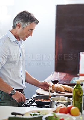Buy stock photo Shot of a mature man cooking in the kitchen