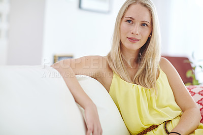 Buy stock photo Shot of an attractive young woman relaxing on her sofa at home