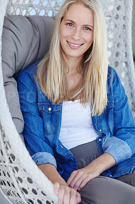 Buy stock photo Shot of an attractive young woman relaxing in a hanging basket chair on her patio