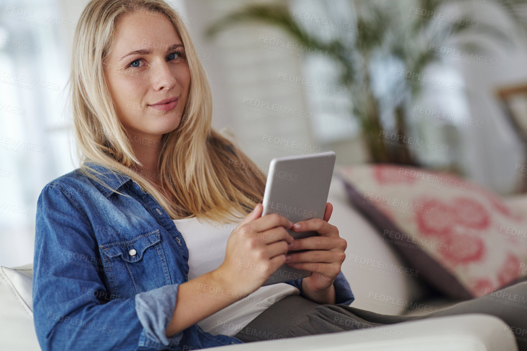Buy stock photo Woman, tablet and smile on sofa in home, streaming and movies on application with portrait in lounge. Girl, happy and multimedia tech for film, web subscription or video on couch at house in Germany