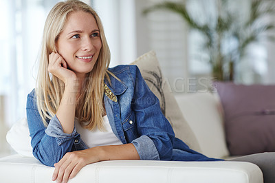 Buy stock photo Shot of an attractive young woman relaxing on her sofa at home