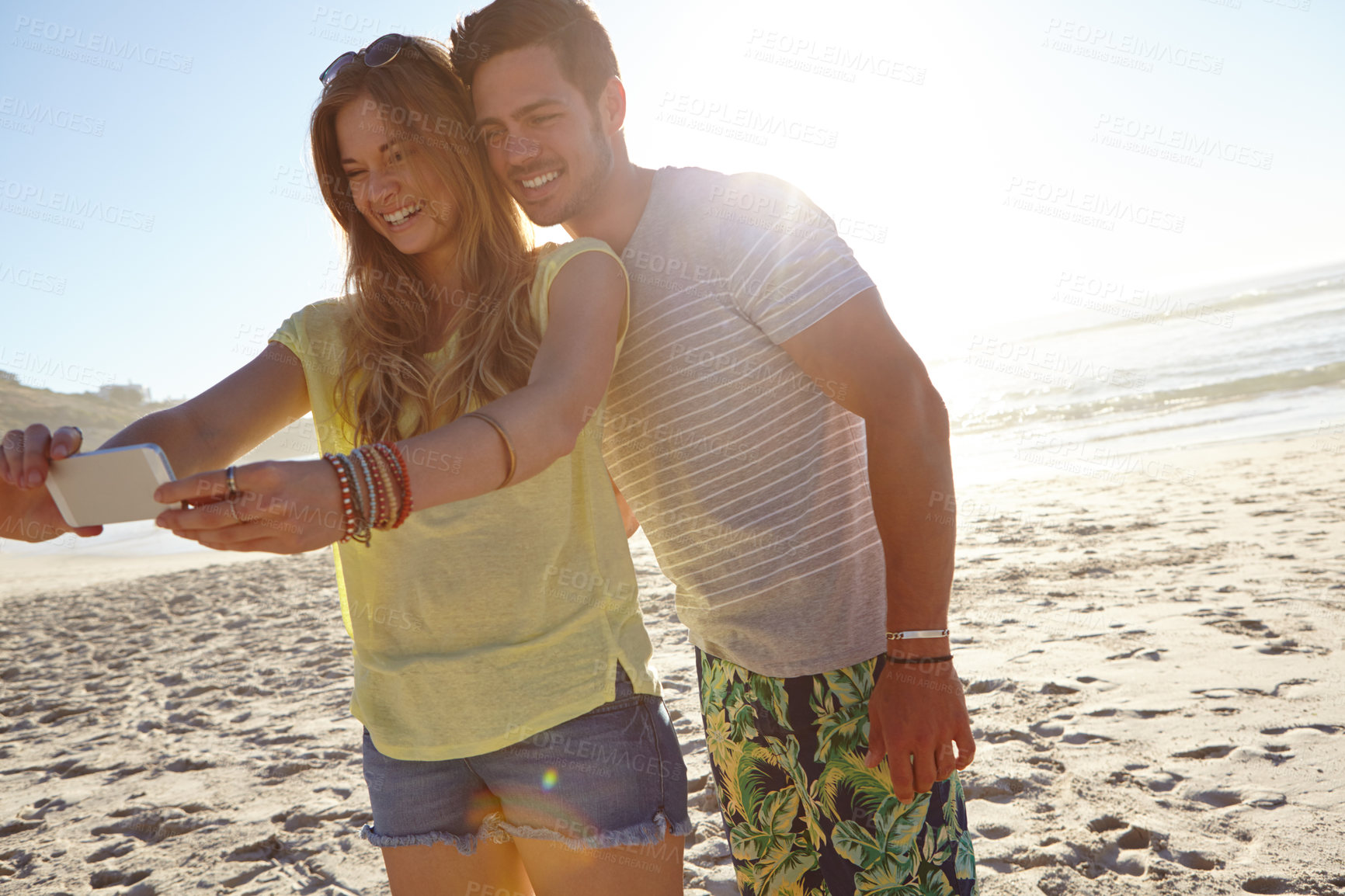 Buy stock photo Cropped shot of an affectionate young couple taking a selfie on the beach