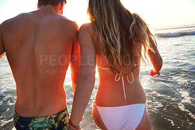 Buy stock photo Rearview shot of a young couple at the beach