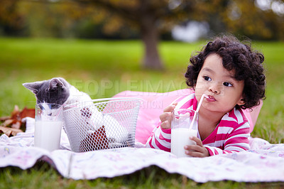 Buy stock photo Milk, picnic and a girl in the park with her cat together for love, care or bonding during summer. Drinking straw, kitten or kids and a happy young child in the garden having fun with her pet animal