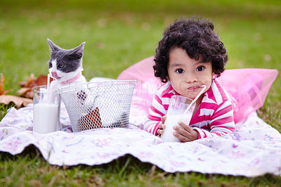 Buy stock photo Portrait, drinking milk and a girl in the park with her kitten together for love, care or bonding during summer. Picnic, cat or kids and a cute child in the garden having fun with her pet animal