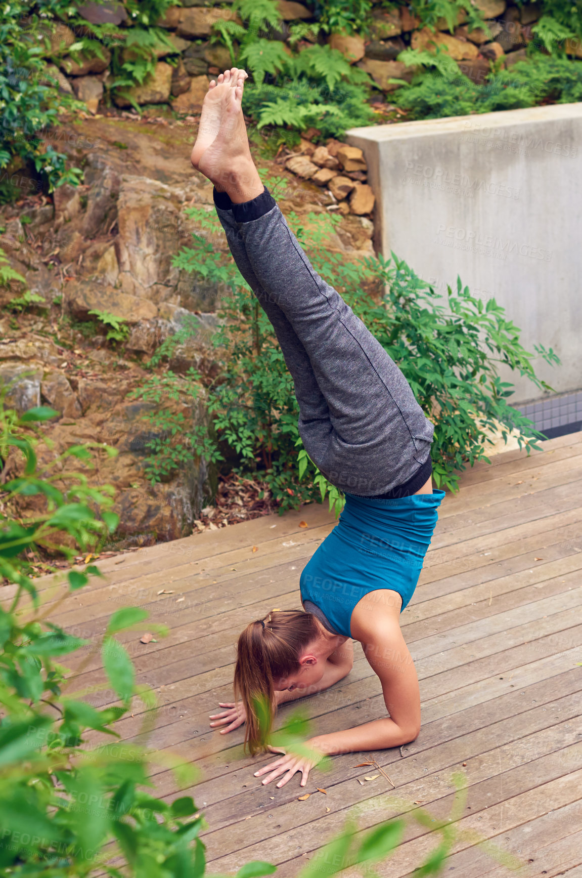 Buy stock photo Shot of a young woman practicing yoga outdoors