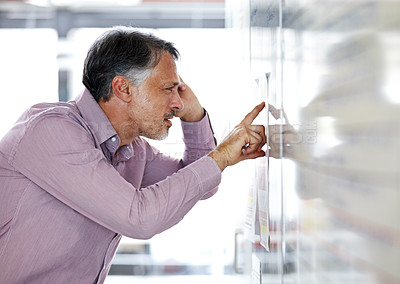 Buy stock photo Senior businessman, pointing and thinking on whiteboard in brainstorming or planning at office. Mature man in wonder, thought or decision for idea, problem solving or solution for agenda at workplace