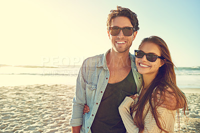 Buy stock photo Couple, ocean and sunglasses with hug, happy or care for fashion, eye protection or vacation in summer. Man, woman and embrace in glasses at beach for sun, style or love by waves on tropical holiday