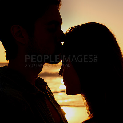 Buy stock photo Couple, love and silhouette embrace on beach at sunset or healing relationship environment, vacation or explore. Happy partnership, hug and shadow at water for forehead kiss for nature, ocean or trip
