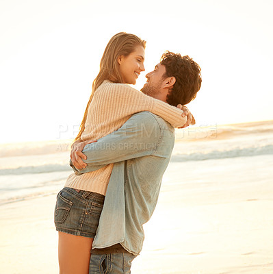 Buy stock photo Smile, hug and young couple at beach on vacation, adventure or holiday for valentines day. Sunset, love and man carry, embrace and bond with woman by ocean for weekend trip on romantic date.