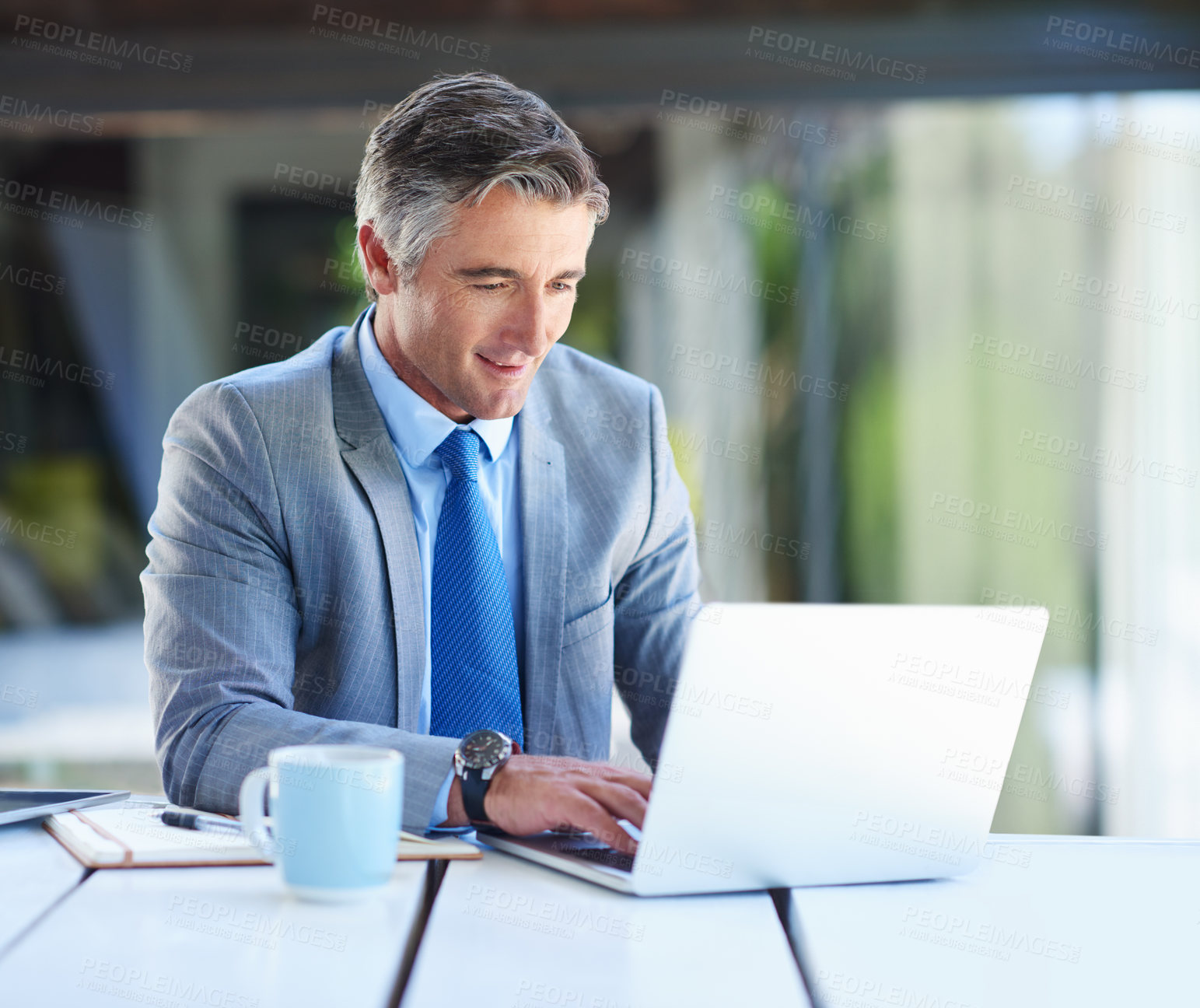 Buy stock photo Shot of a mature businessman working on a laptop