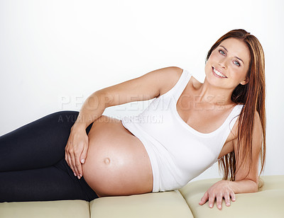 Buy stock photo Cropped shot of a pregnant woman holding her belly while relaxing
