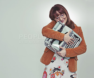 Buy stock photo Studio shot of a bookish young woman in retro clothing hugging her typewriter