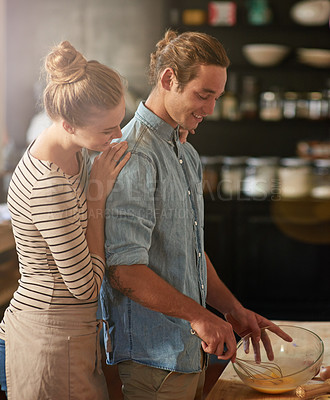Buy stock photo Shot of a young couple bonding in the kitchen