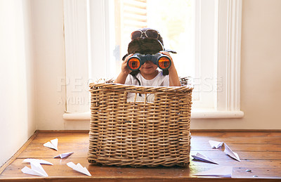 Buy stock photo Shot of an adorable little boy sitting playing in a basket among paper jets